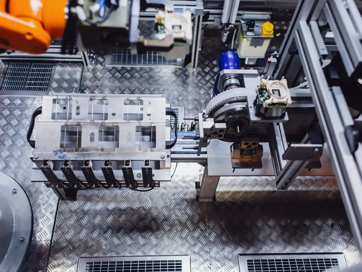 Vogelperspektive auf eine automatisierte Montagezelle mit einem Werkstückträger, Sensorik und einem Industrieroboter in der Produktion für Sondermaschinenbau bei AWM Arnstadt.