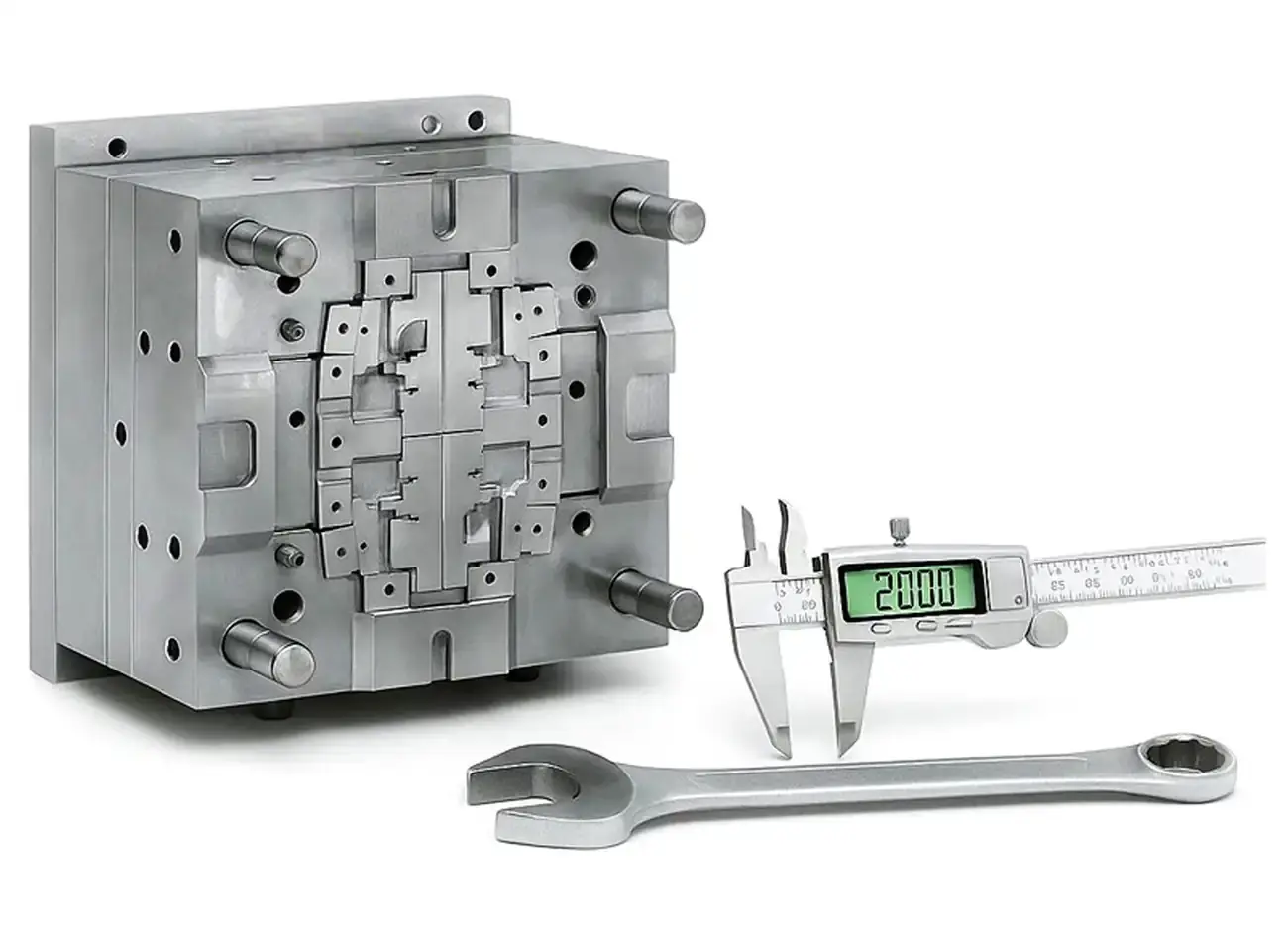 Precision-engineered mold half of an AWM injection mold with guide pins, wrench, and digital caliper.