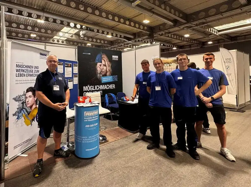 AWM trade fair team and apprentices at the AWM exhibition booth during the career fair.