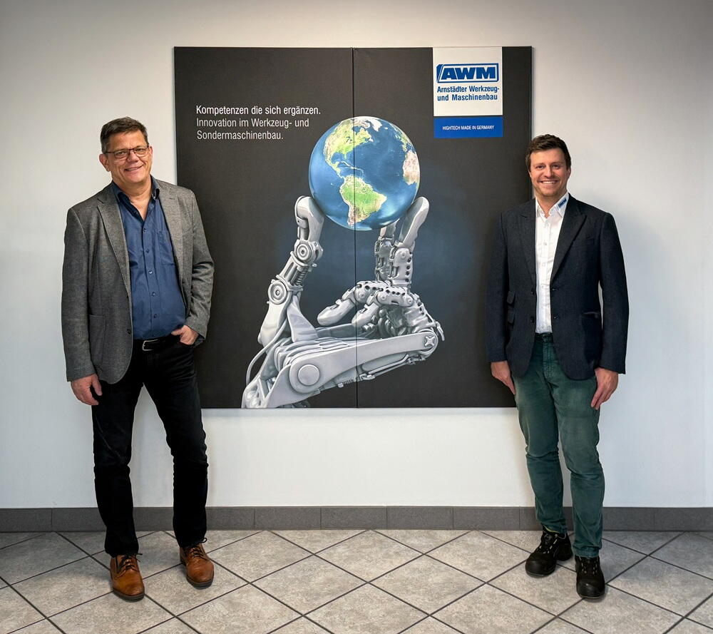 Employees in front of AWM posters