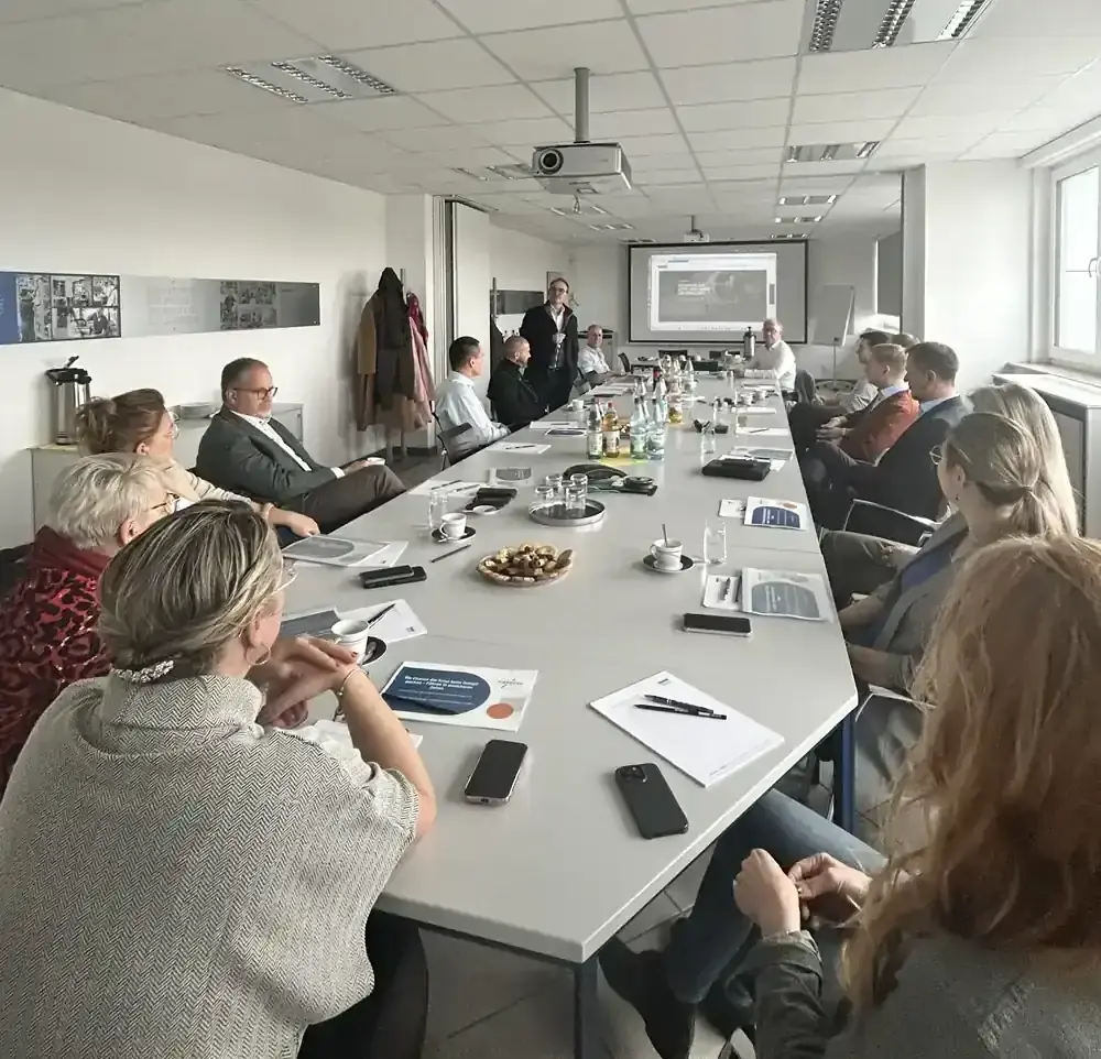 Participants of the IEK meeting and leadership workshop seated around a long conference table at AWM.