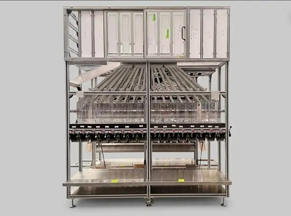 Frontalansicht einer freigestellten industriellen Separierstation aus Aluminiumprofilen mit mehrstufigen Führungskanälen auf grauem Hintergrund.